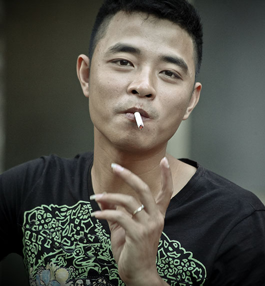 Jeune homme fume rue hanoi vieux quartier vietnam